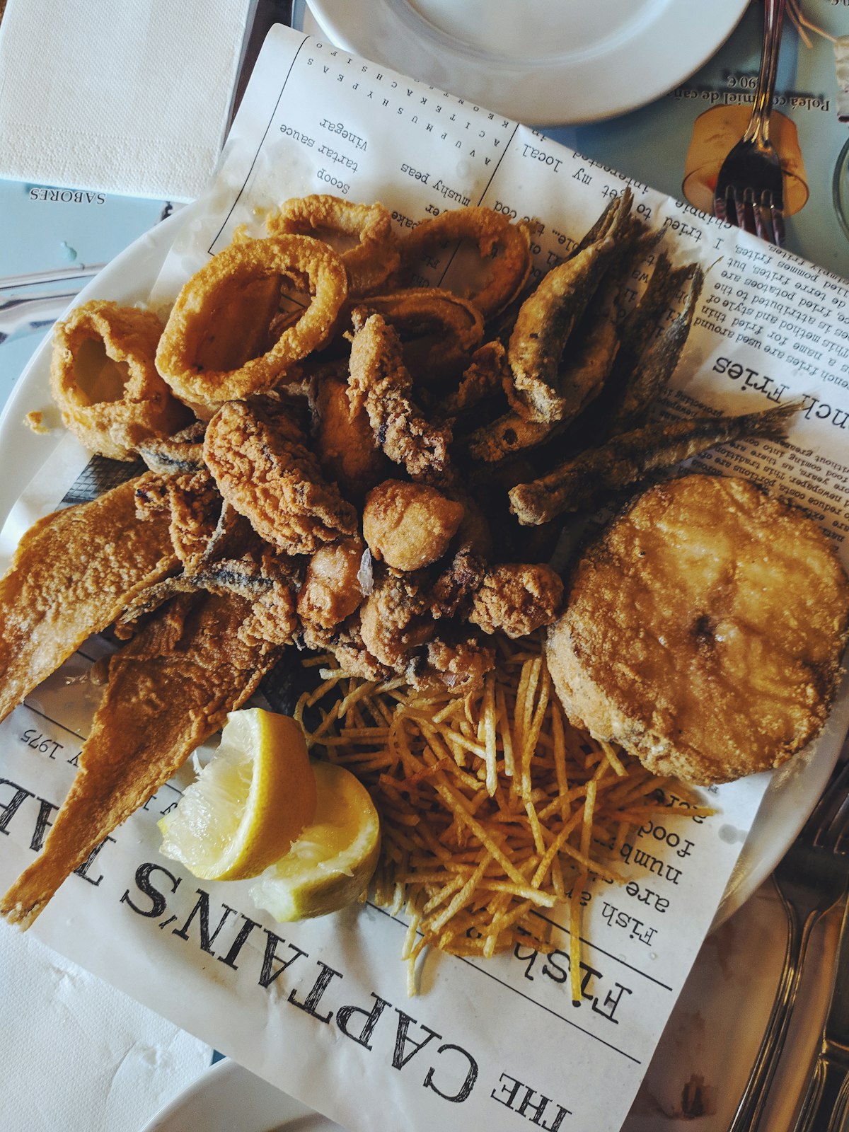 Fritto misto di pesce con patatine e limone